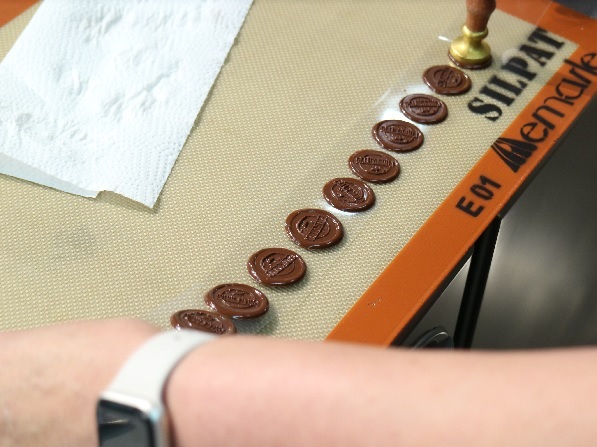 ▲シュークリームの上の飾りのチョコレートプレートも手作り。刻印を押しているところ。